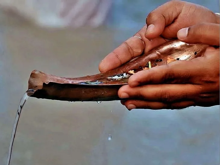 Tarpan water offered from a copper vessel
